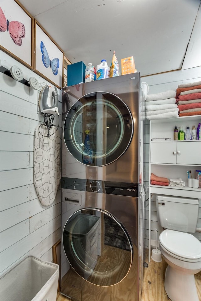 322 Boone, Alvarado, TX 76009 - laundry room featuring stacked washer and clothes dryer, light wood finished floors, and laundry area