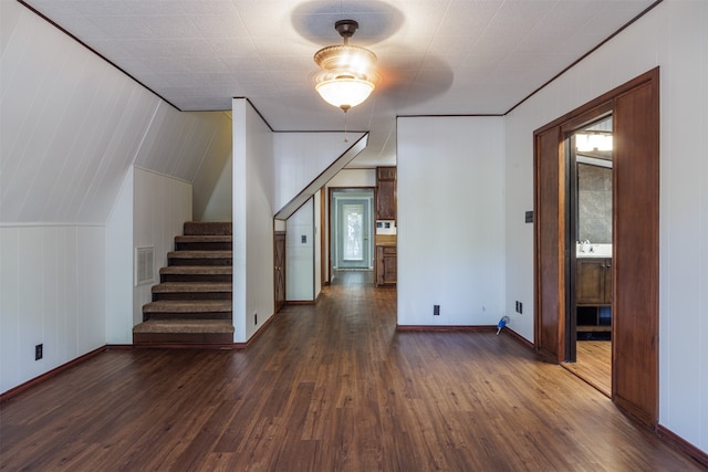 interior space featuring wooden walls, lofted ceiling, and dark hardwood / wood-style flooring