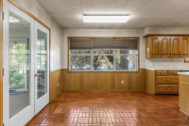 kitchen with a textured ceiling and wooden walls