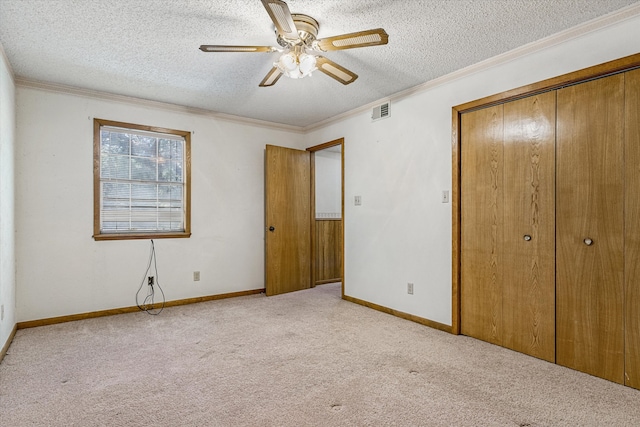 unfurnished bedroom with a textured ceiling, light carpet, ceiling fan, and a closet