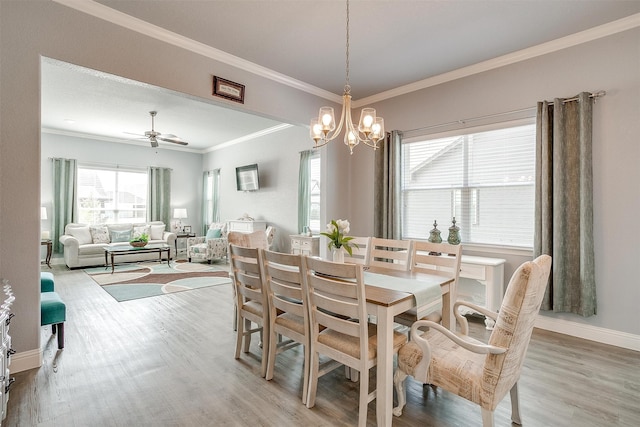 dining area featuring ornamental molding, ceiling fan with notable chandelier, and light wood-type flooring