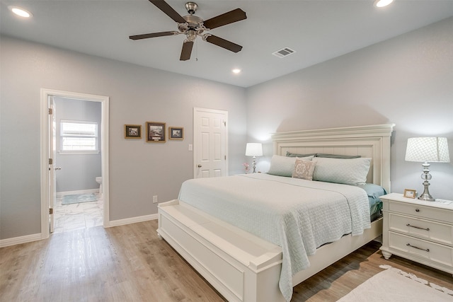 bedroom featuring light wood-type flooring, ensuite bath, and ceiling fan