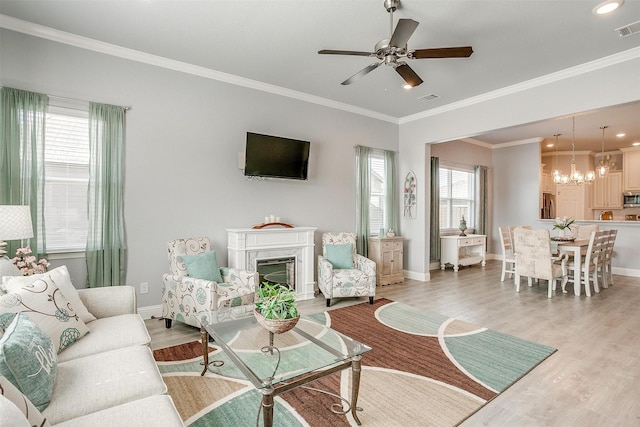 living room featuring crown molding, ceiling fan, and light wood-type flooring