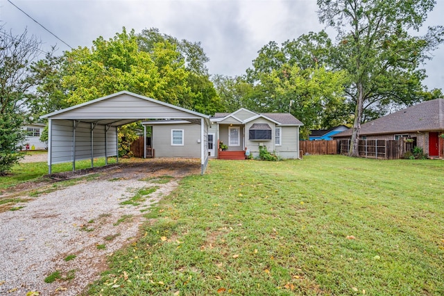 view of front facade with driveway, a front yard, fence, and a detached carport