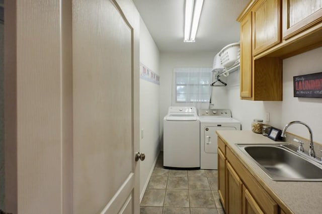 laundry room featuring light tile patterned flooring, washer and dryer, sink, and cabinets