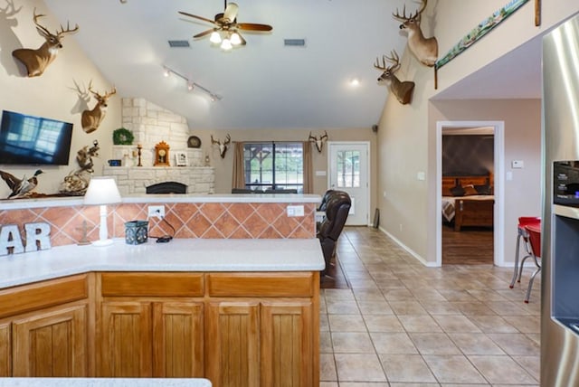 kitchen with stainless steel refrigerator with ice dispenser, backsplash, vaulted ceiling, ceiling fan, and light tile patterned flooring