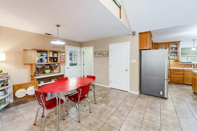 dining area with light tile patterned floors, sink, and vaulted ceiling