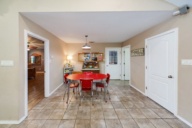 tiled dining space with ceiling fan