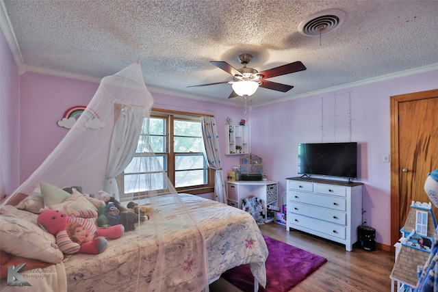 bedroom featuring ceiling fan, ornamental molding, a textured ceiling, and dark wood-type flooring