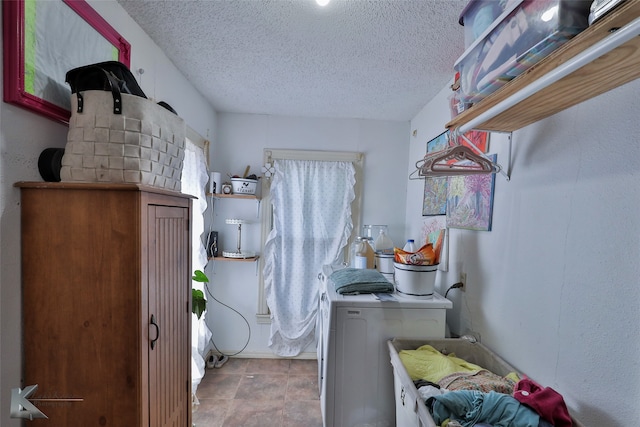 laundry area with a textured ceiling and washing machine and clothes dryer