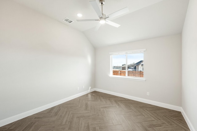 empty room featuring parquet flooring, ceiling fan, and vaulted ceiling