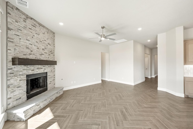 unfurnished living room featuring parquet flooring, ceiling fan, and a stone fireplace