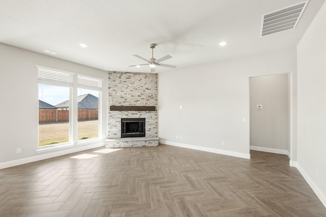 unfurnished living room with ceiling fan, parquet flooring, and a large fireplace