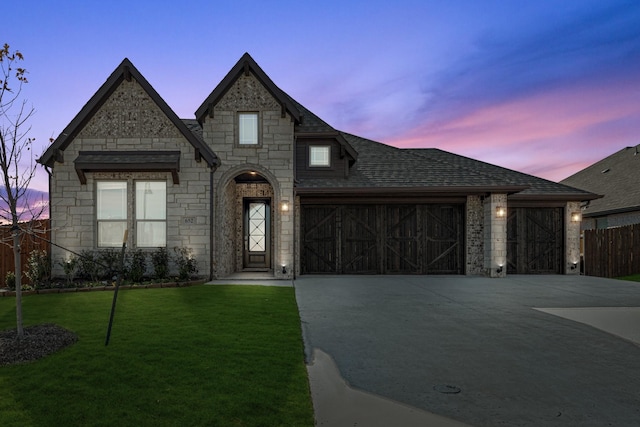 french country home with a garage and a yard