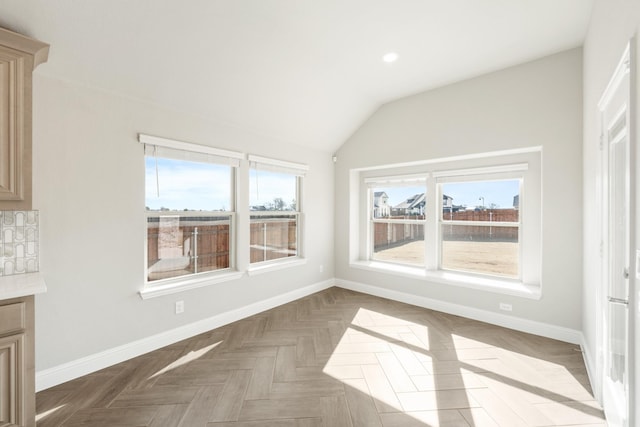 unfurnished dining area with parquet floors and vaulted ceiling