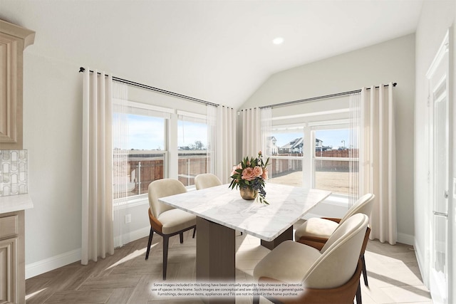 dining room with light parquet flooring, plenty of natural light, and lofted ceiling