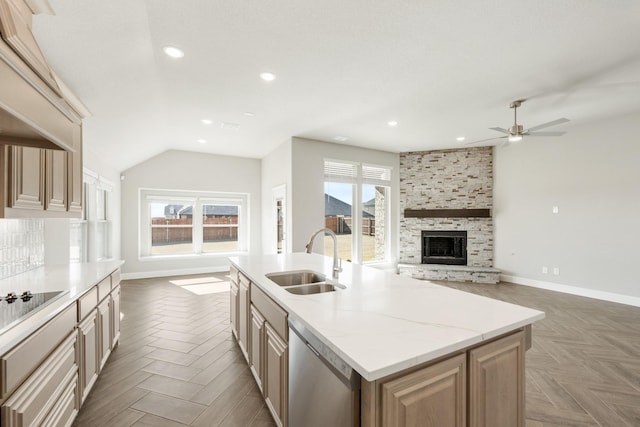 kitchen featuring parquet flooring, a wealth of natural light, dishwasher, sink, and a kitchen island with sink