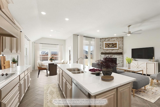 kitchen with a kitchen island with sink, sink, a fireplace, and light parquet flooring