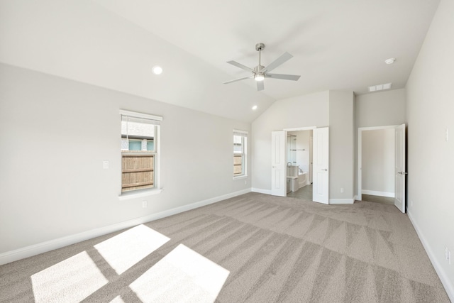 unfurnished bedroom with ceiling fan, ensuite bath, lofted ceiling, and light carpet