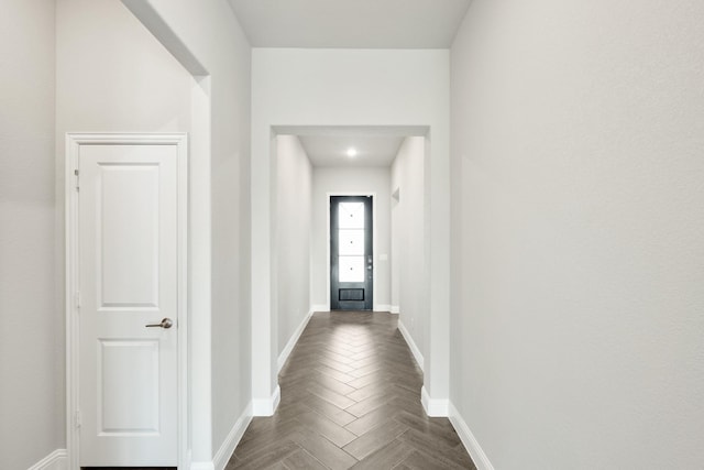 hallway featuring dark parquet flooring