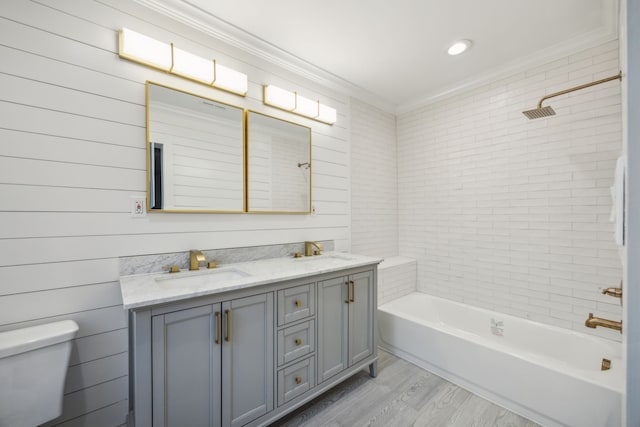 full bathroom with wood-type flooring, shower / bath combination, ornamental molding, vanity, and toilet