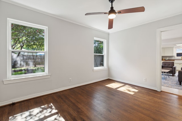 unfurnished room with a healthy amount of sunlight, dark hardwood / wood-style floors, and ceiling fan