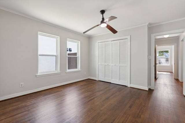 unfurnished bedroom featuring multiple windows, dark hardwood / wood-style floors, ceiling fan, and a closet