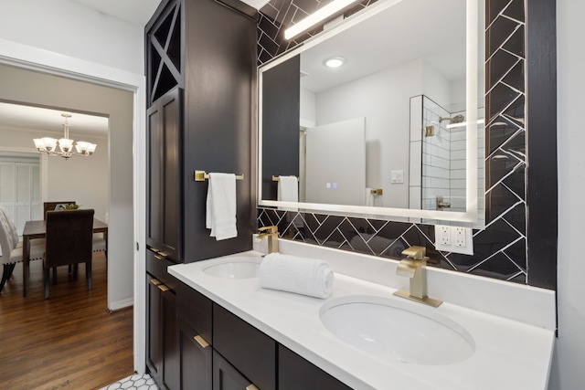 bathroom featuring a shower, decorative backsplash, vanity, hardwood / wood-style floors, and a notable chandelier