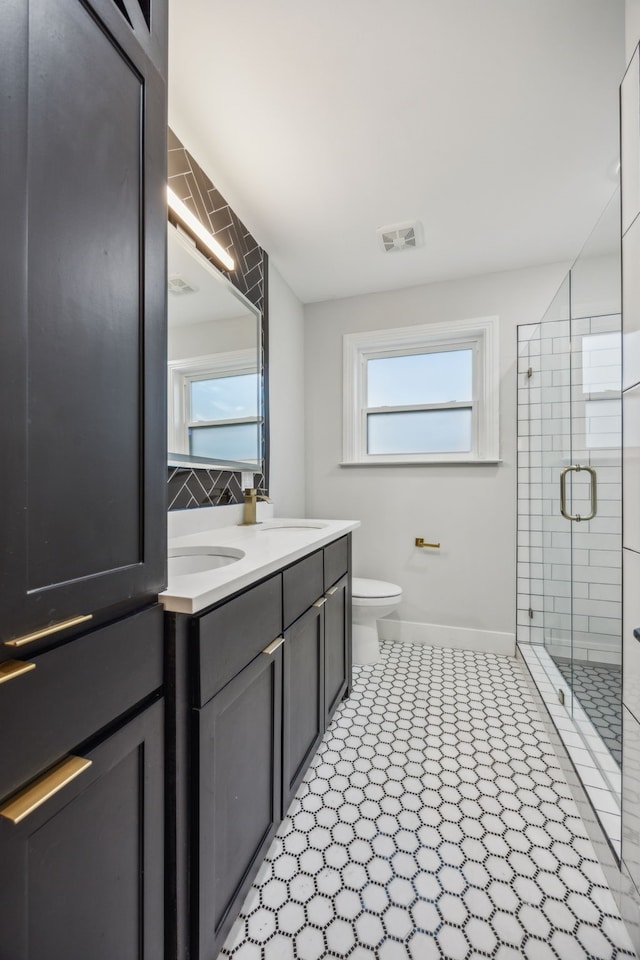 bathroom featuring tile patterned flooring, vanity, toilet, and an enclosed shower