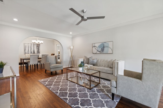 living room with ceiling fan with notable chandelier, ornamental molding, and dark hardwood / wood-style flooring