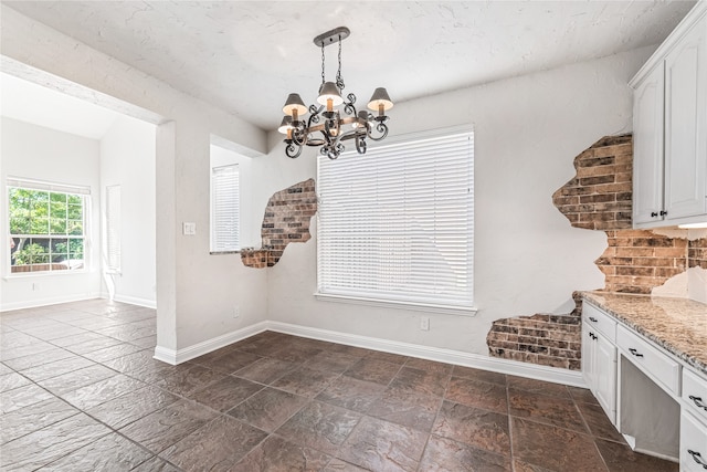 unfurnished dining area with a notable chandelier