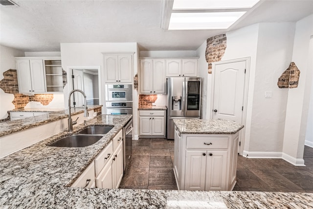 kitchen featuring stainless steel appliances, white cabinetry, and sink