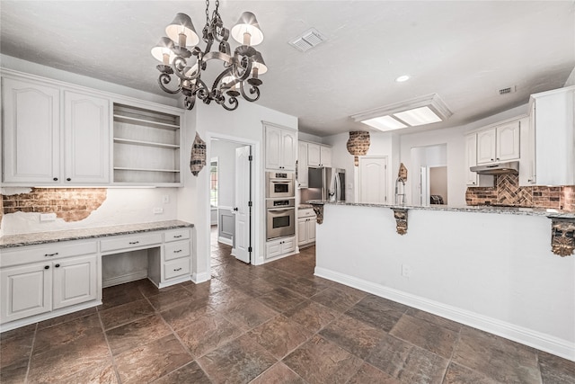 kitchen featuring light stone countertops, white cabinetry, and decorative light fixtures