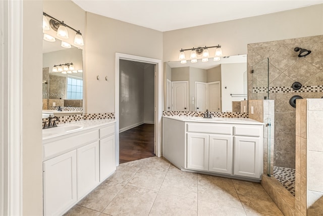 bathroom featuring a tile shower, tile patterned flooring, vanity, and tasteful backsplash