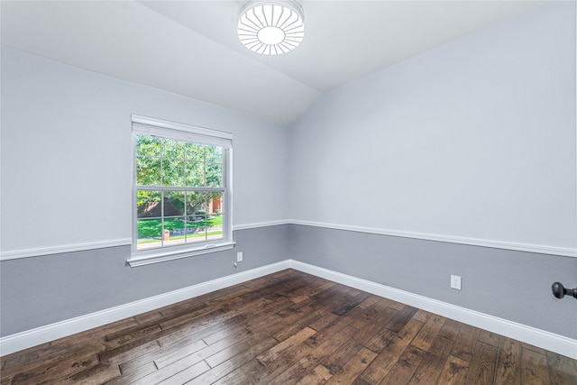 spare room featuring vaulted ceiling and dark wood-type flooring