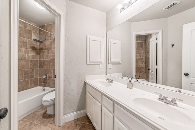 full bathroom featuring tiled shower / bath combo, vanity, and toilet