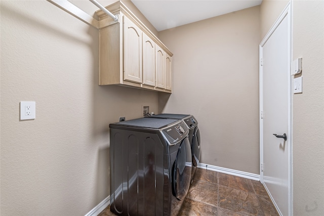 laundry room featuring separate washer and dryer and cabinets