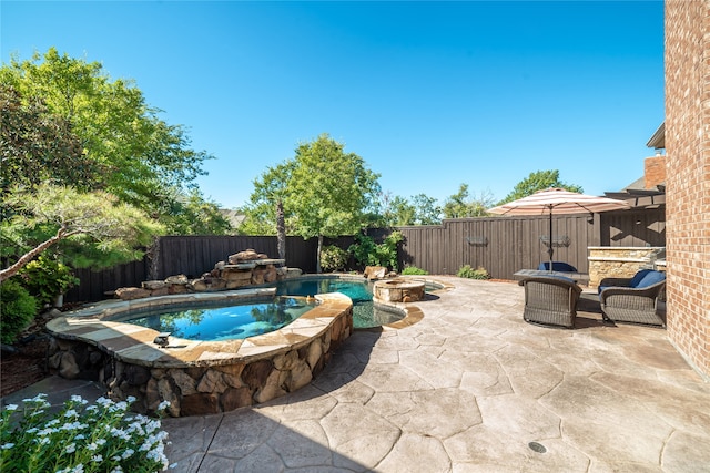 view of pool featuring a patio and an in ground hot tub