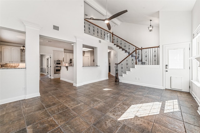 entryway featuring ornate columns, beamed ceiling, ceiling fan, and high vaulted ceiling