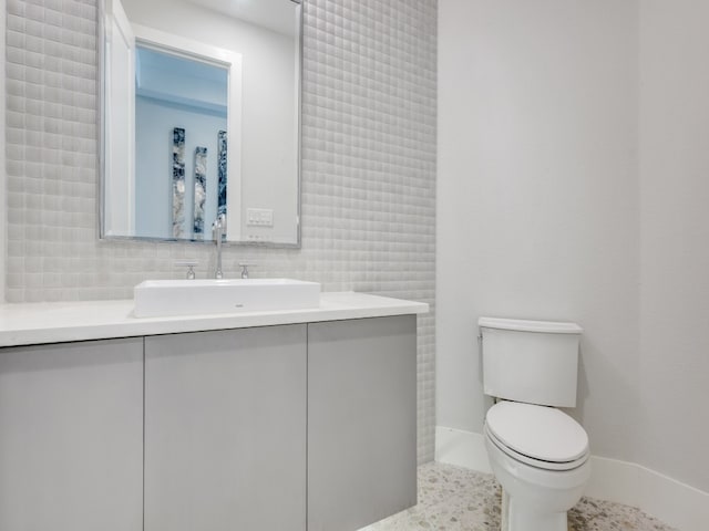 bathroom featuring tile walls, decorative backsplash, tile patterned floors, vanity, and toilet