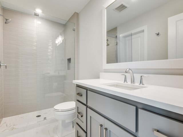 bathroom featuring tiled shower, vanity, and toilet