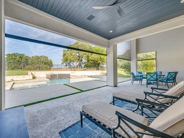 view of patio with ceiling fan and a pool with hot tub