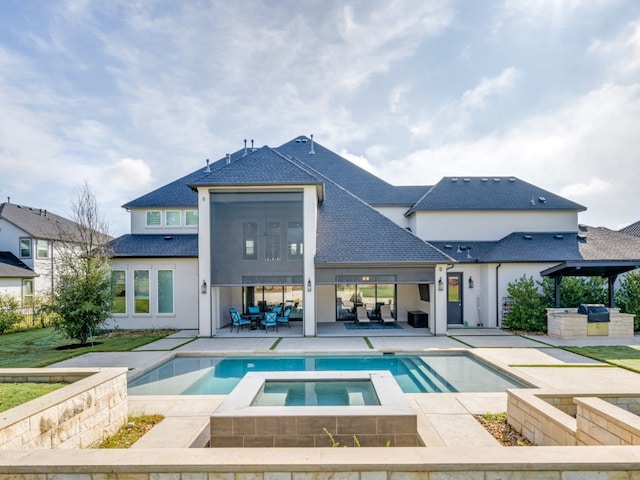 rear view of property with a swimming pool with hot tub and a patio area