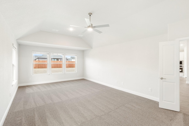 carpeted spare room with ceiling fan and lofted ceiling