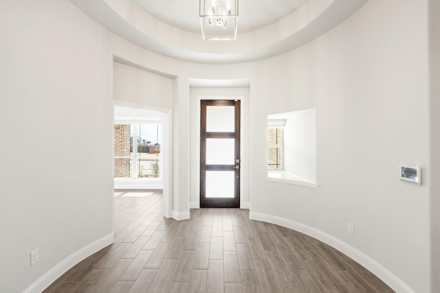 entryway featuring a notable chandelier and a tray ceiling