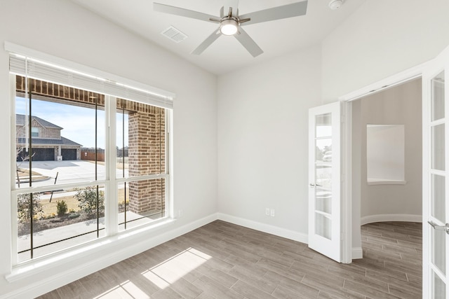 spare room with ceiling fan and french doors