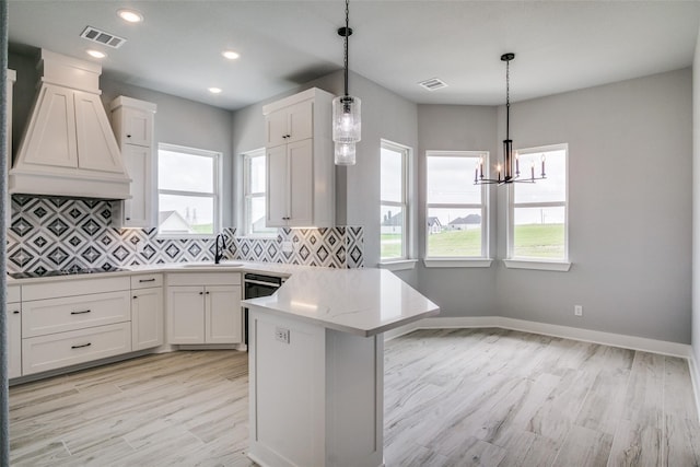 kitchen with white cabinetry, sink, and plenty of natural light