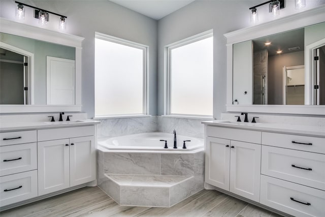 bathroom featuring vanity, plus walk in shower, and hardwood / wood-style flooring