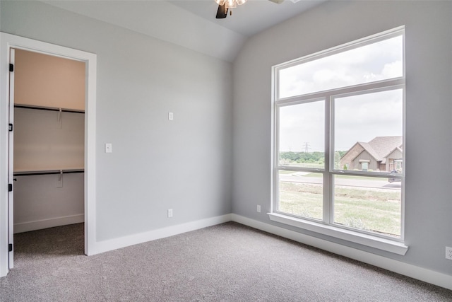 unfurnished bedroom featuring carpet floors, a closet, a spacious closet, and ceiling fan