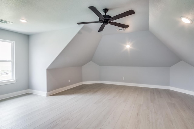 additional living space featuring ceiling fan, a textured ceiling, light hardwood / wood-style flooring, and lofted ceiling